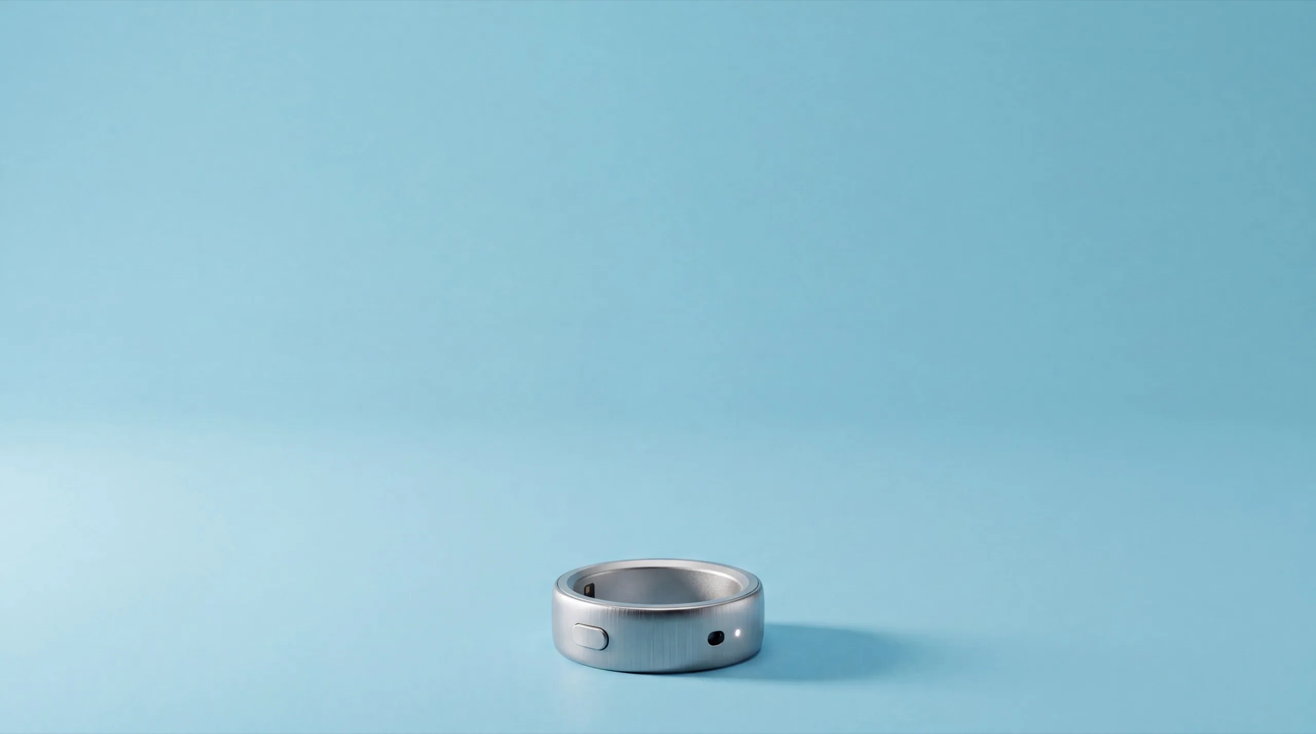 The interface ring standing on a pastel azure backdrop, its status LED glowing